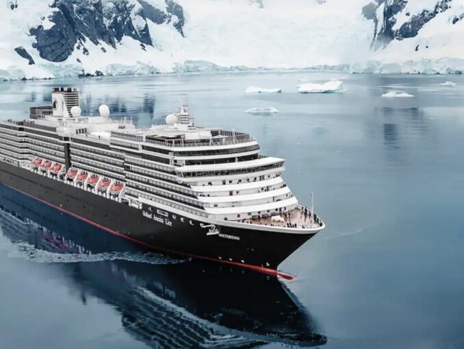 Large cruise ship sailing through icy Arctic waters with snow-covered cliffs in the background.
