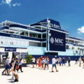 Multi-level MSC Cruises terminal building in blue and white with crowds outside on a sunny day.