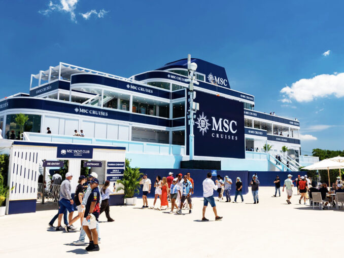 Multi-level MSC Cruises terminal building in blue and white with crowds outside on a sunny day.