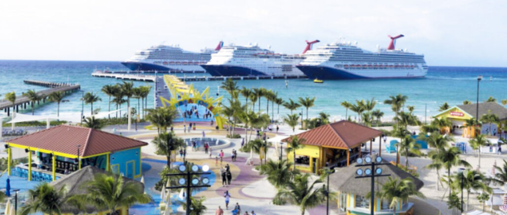Two large cruise ships docked offshore as a sunny tropical port comes to life with palm trees and colorful buildings along a promenade.